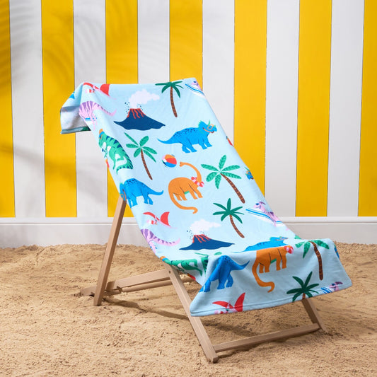 Dinosaur themed children’s microfibre beach towel displayed on deckchair, lightweight pool towel