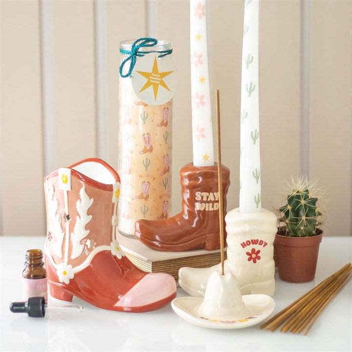 pink cowboy boot oil burner styled in cosy home setting with decorative flair