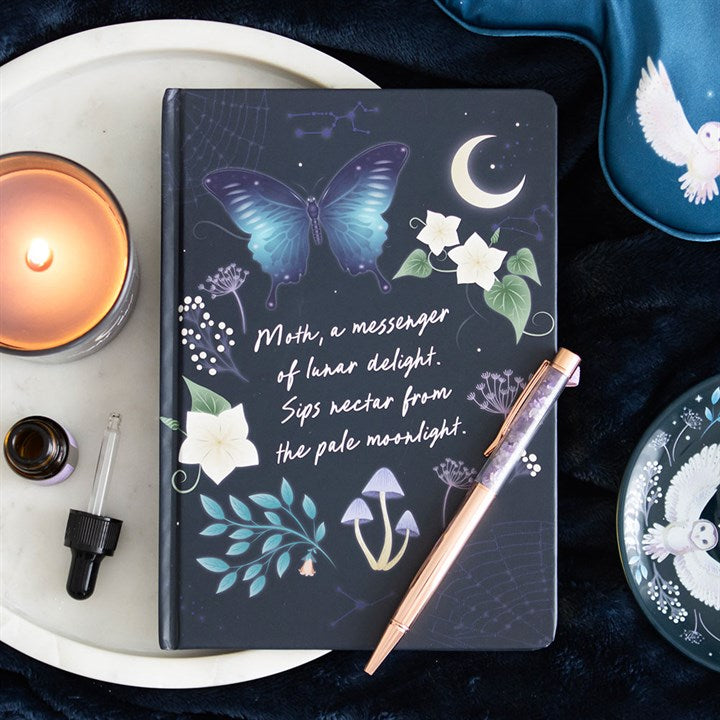 midnight moth journal and crystal pen displayed together in atmospheric home setting