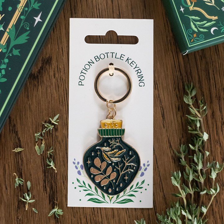 green witch potion bottle keyring displayed flat on table with mystical charm design