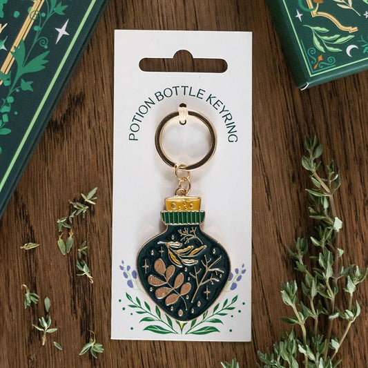green witch potion bottle keyring displayed flat on table with mystical charm design